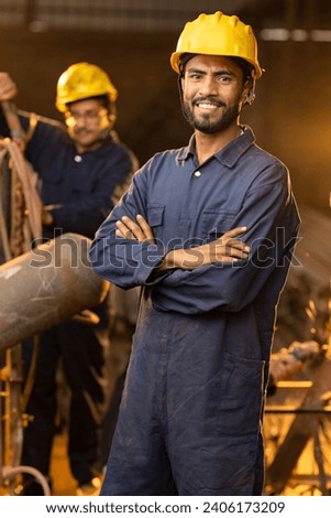 Industrial worker at factory, looking at camera.