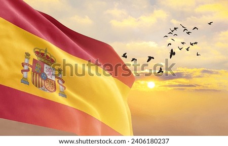 Waving flag of Spain against the background of a sunset or sunrise. Spain flag for Independence Day. The symbol of the state on wavy fabric.