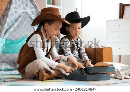 Cute little cowboys with typewriter at home