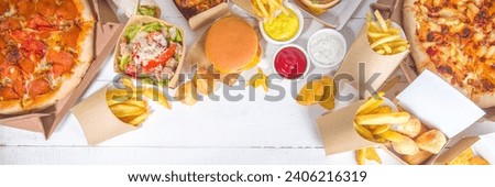 Delivery fastfood ordering food online concept. Large set of assorted take out foods pizza, french fries, fried chicken nuggets, burgers, salads, chicken wings, various sides, white table background  Royalty-Free Stock Photo #2406216319