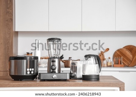 Set of appliances on wooden table in contemporary kitchen Royalty-Free Stock Photo #2406218943