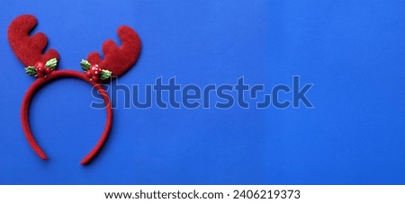 cute christmas headbands with funny red deer horns isolate on a ิblue backdrop. concept of joyful christmas party,new year is coming soon, festive season decoration with christmas elements