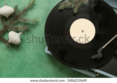 Christmas music concept with turntable and holiday decorations on green grunge background
