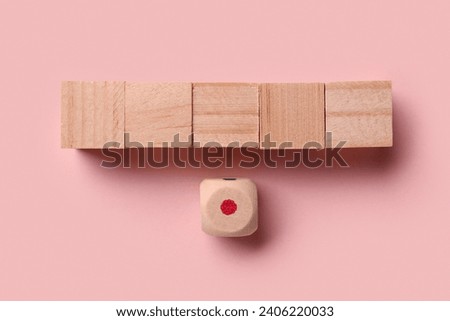 Wooden cubes with dot on pink background