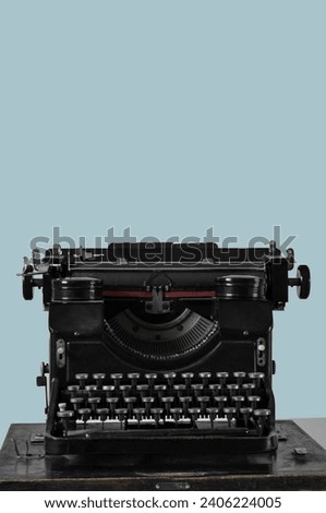 Vintage typewriter on table near light wall