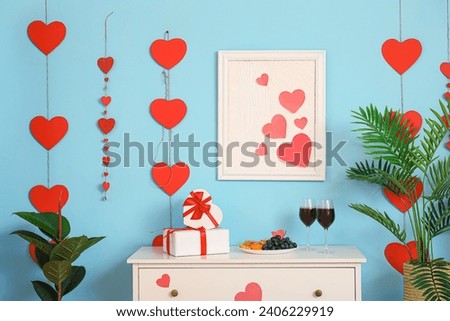 Chest of drawers with gift boxes and hearts in modern living room. Valentine's Day celebration Royalty-Free Stock Photo #2406229919
