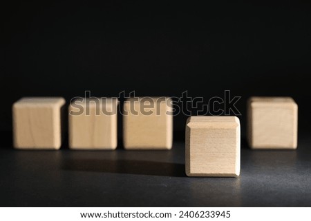 Empty wooden cubes on grey table against black background