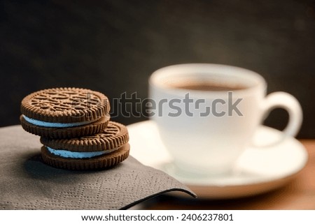 Closeup of fragrant fresh black Turkish coffee with chocolate cinnamon cookies with cream. Dark background. Energy drink ad. Coffee break in cafe. Caffeine advertisement. Italian espresso ads. Biscuit Royalty-Free Stock Photo #2406237801