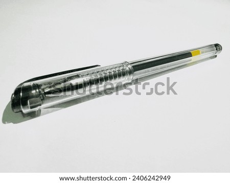 Transparent Ballpoint Pen. Clear plastic ballpoint pen with a yellow accent on a bright background. Royalty-Free Stock Photo #2406242949