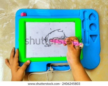 Children's hands are learning to draw using magnetic educational boards made of plastic, this educational board can also be used to learn to write