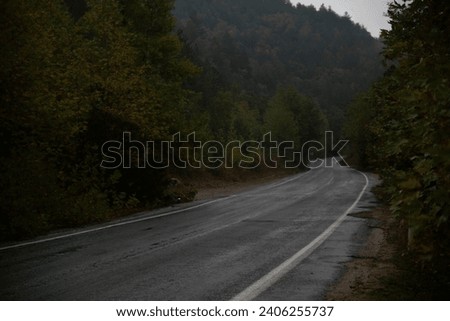 a dark road between forest trees and mountains sky autumn colors countryside road beauttiful nature kazdaglari ida mountains