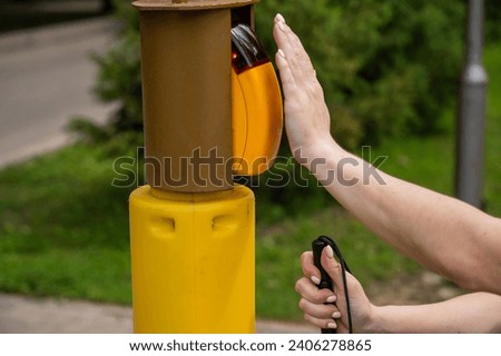 Close-up of a blind woman's hand pressing a button for a traffic light. 