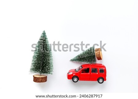 Greeting card with Christmas tree on the roof of read car toy, top view.