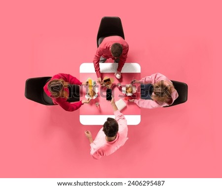 Creative collage. Aerial view of young people, colleagues eating delivery food against pink background. Copy space. Concept of business lunch, morning meeting, briefing. Ad