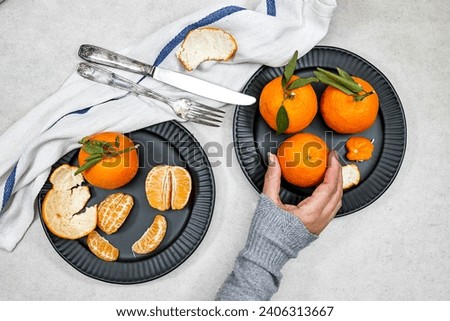 woman eating a fresh ripe mandarine Royalty-Free Stock Photo #2406313667