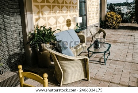 Dining coffee table with chairs on tile floor exterior. Living area in countryside house or hotel. Beautiful urban architectural photography. High quality picture for wallpaper, article