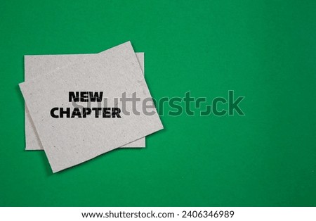 New chapter lettering on paper paper piece with green background. Business concept photo. Top view, copy space.