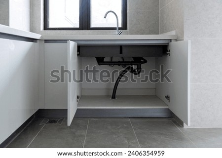 Open the cabinet under the sink Royalty-Free Stock Photo #2406354959