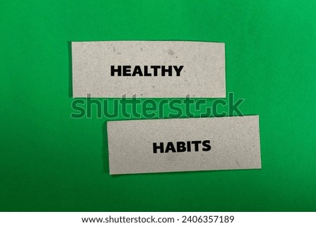 Healthy habits lettering on ripped paper pieces with green background. Conceptual photo. Top view, copy space.