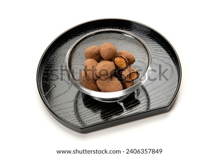 Chocolate coated almonds on a white background