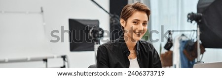 happy pretty professional female photographer in casual attire smiling and looking at camera, banner