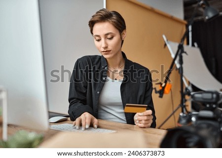charming young female photographer in casual comfy attire paying online with her credit card
