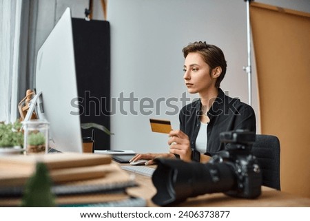 beautiful young female photographer in casual comfy attire paying online with her credit card