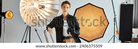 attractive young female photographer in casual attire looking at camera while at her studio, banner