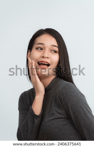 Asian woman braces. Teeth braces on the white teeth of women to equalize the teeth. Bracket system in smiling mouth, close up photo teeth, macro shot, dentist health concept. Royalty-Free Stock Photo #2406375641