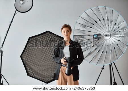 young good looking female photographer in casual attire looking at camera while at her studio