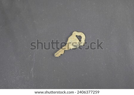 A rusty old brass key of medium size on a black background tilt potition