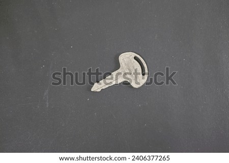 Old rusty metal motorbike key tilt positioned on a black background