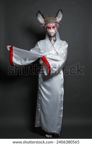 Perfect theater actress woman with asian style makeup and dress standing on black studio wall background