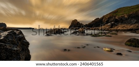Kynance Cove beach long exposure photo panoramic sunset view with cloudy sky, The Lizard Peninsula, Cornwall. South West England.