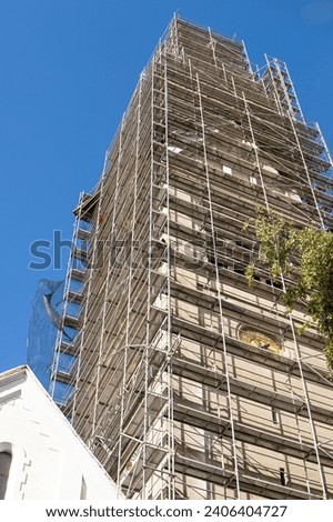 Reconstruction of the facade of a high-rise building scaffolding. Vertical photo.