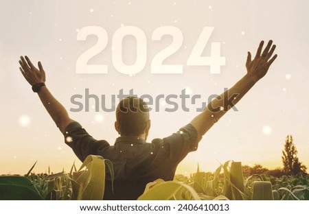 A happy and satisfied young man is spreading his hands in the air and enjoying the sunset welcoming the new 2024 year. Concept of success, dedication and future.