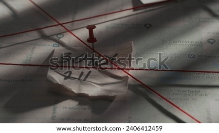 Close up shot of investigation board. Detective board with map of crime scene, pinned note with numbers and red thread connecting clue proofs. Royalty-Free Stock Photo #2406412459