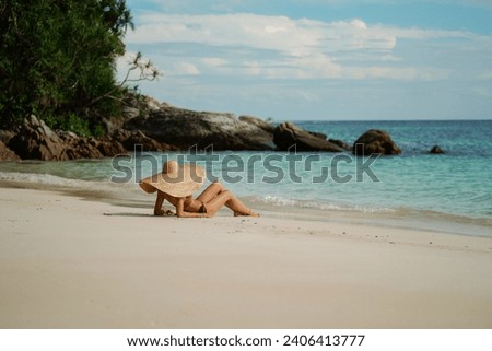 Vacation. Summer. Woman relaxing on the sandy tropical beach wearing big hat, sunbathing. Travel. Tourist. Thiland. Asia.