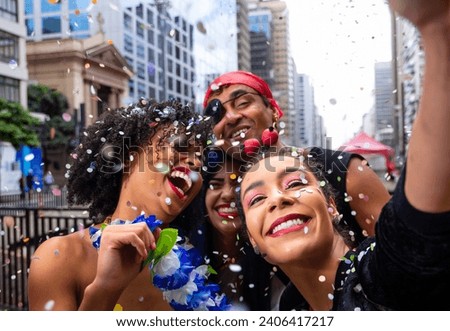 Girls taking selfie at street party parade, brazilian carnaval. Group of Brazilian friends in costume celebrating. Royalty-Free Stock Photo #2406417217