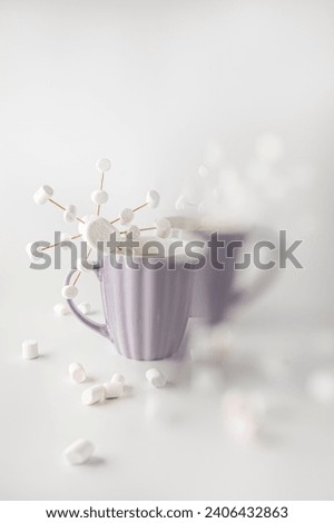 A purple mugs with hot coffee and marshmallows. Two cups with marshmallows in snowflake shapes. Blur part of image.