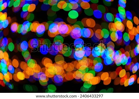 Large vibrant green, red, orange and blue bokeh balls swirling and creating magical ornament. Abstract high resolution background. Real photo.