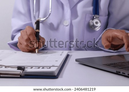 Close up of the ears of a professional female doctor in uniform taking notes in a notebook Medical therapist filling out medical documents. Clipboard. Patient form. Illness history, prescription