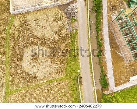 Industrial Photography Landscapes. Bird's-eye view of Buildings on the edge of rice fields under construction. Aerial Shot from a flying drone. Bandung - Indonesia, Asia