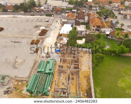 Industrial Photography Landscapes. Bird's-eye view of Buildings on the edge of rice fields under construction. Aerial Shot from a flying drone. Bandung - Indonesia, Asia