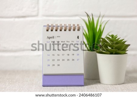 Desk calendar for April 2024 and a clock on the table Royalty-Free Stock Photo #2406486107