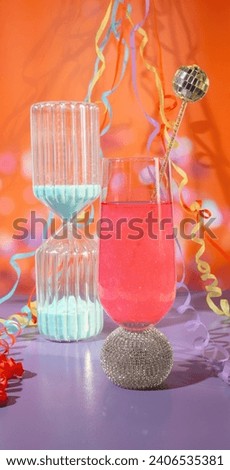 A Sand Timer Countdown and a Glass of Pink Celebration Toasting Glittering Champagne with Party Streams and Confetti, New Years Countdown Event