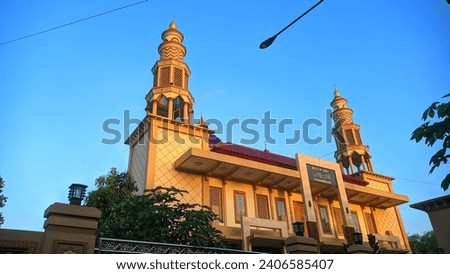 The large mosque has a golden yellow color, combined with the blue of the sky, 
