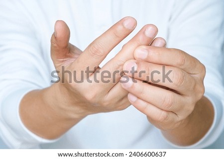 Hand of man she massages his thumb and has finger pain, locked finger from work and office syndrome. on a white background medical concept