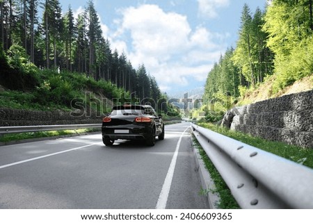 Picturesque view of asphalt road with modern car Royalty-Free Stock Photo #2406609365