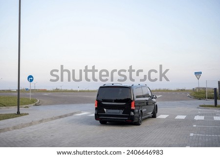 Black luxury minivan taxi on parking lot outdoors Royalty-Free Stock Photo #2406646983